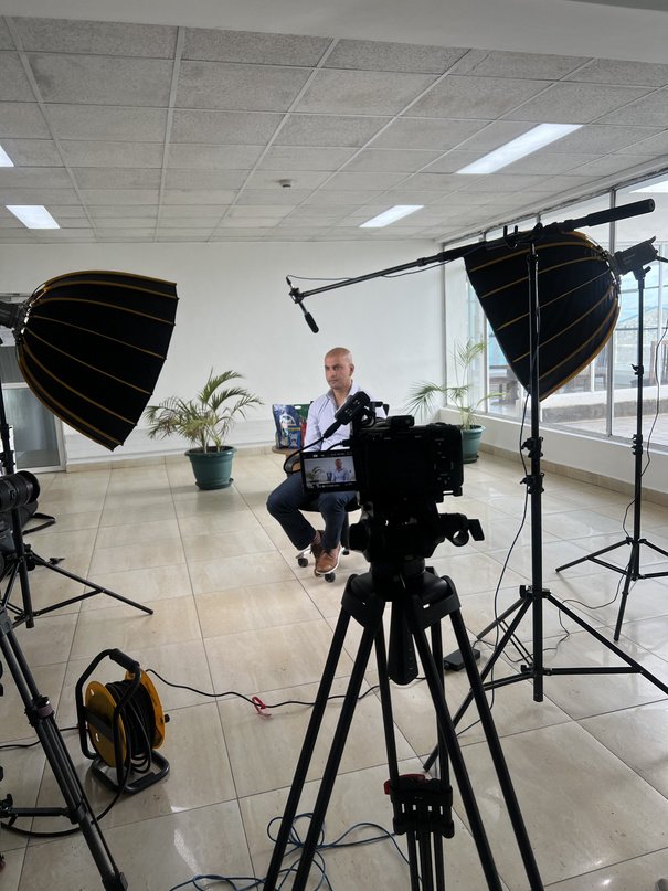 Seated interview lit by two large parabolic softboxes with a boom overhead